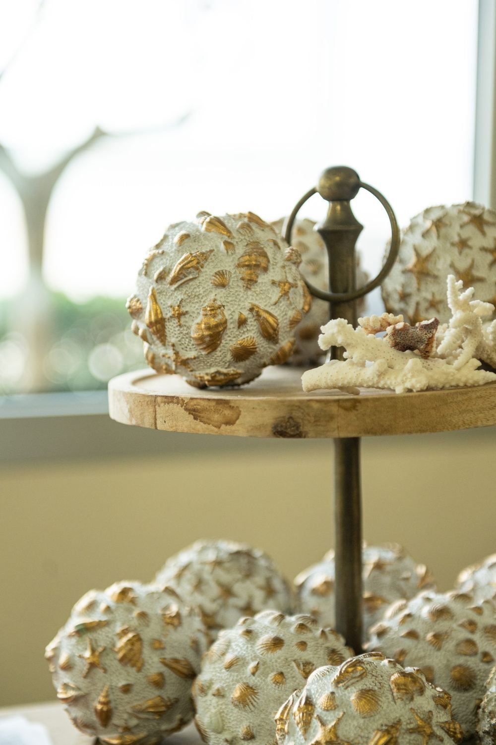 Sfere decorative di conchiglie e corallo su un'alzatina in legno